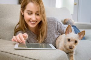 Femme sur tablette avec chien à la maison - télémédecine