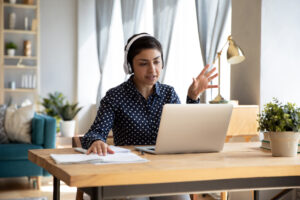 mulher em um computador em sua casa com fone de ouvido