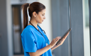 Woman in scrubs holding a tablet in her hands 