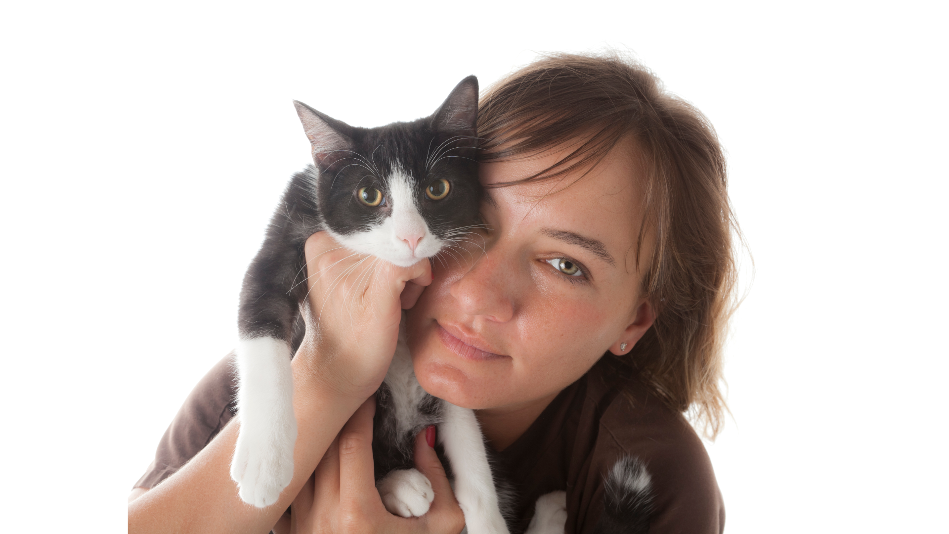 A female veterinary technician holding a cat up close to her head on a white background